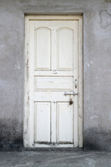 Fototapeta premium An old white wooden door, bolted and padlocked.