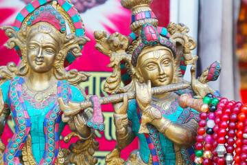 Sri Krishna plays the flute. Bronze Indian religious figurine decorated with stones.