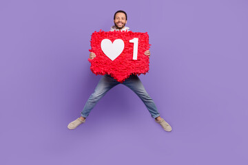 Full length body photo of jumping youngster popular tik tok media community user hold red like pinata share isolated on violet background - obrazy, fototapety, plakaty