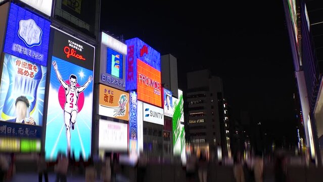 OSAKA, JAPAN : View of Dotonbori area. Tourist destinations, filled with neon signs, clubs and restaurants. Time lapse shot, sunset to night. Logo and signs are blurred or overwritten for this video.