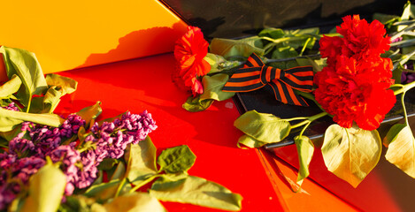 Victory Day, 9 May holiday concept. ribbon of St.George and flowers, natural spring background. traditional symbol of Victory Day 1945. memory of war 1941-1945