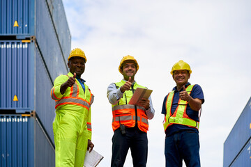 Team of foreman stand on container box and trumb up for confirm good service of logistic