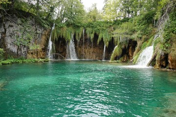 Waterfalls flowing into a blue lake at Plitvice Lakes National Park