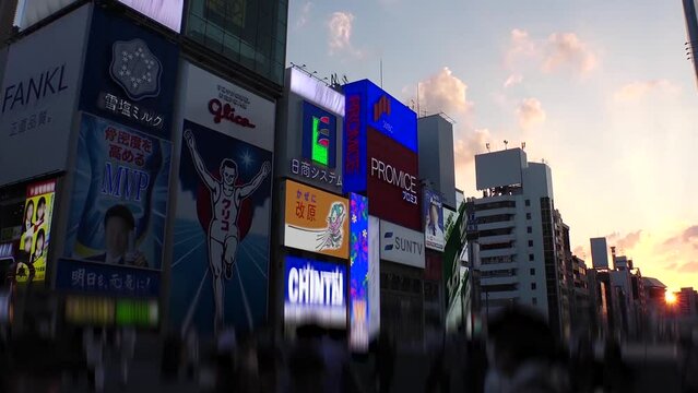 OSAKA, JAPAN : View of Dotonbori area. Tourist destinations, filled with neon signs, clubs and restaurants. Time lapse shot, sunset to night. Logo and signs are blurred or overwritten for this video.