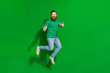Fototapeta na wymiar Full length photo of satisfied guy ginger beard dressed stylish t-shirt showing thumbs up good job isolated on green color background