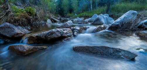 Beautiful view of a river flowing through big stones
