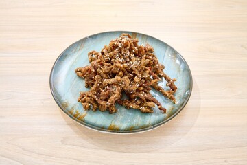 Closeup of a delicious dinner with seasoned chicken and rice in a round blue plate on a wooden table