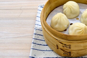Closeup of delicious Chinese xiaolongbao steamed buns on a xiaolong bamboo steaming basket