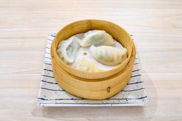 Closeup of Asian dumplings in a wooden bowl.