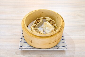Closeup of Asian dumplings in a wooden bowl.