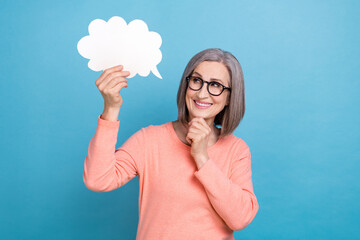 Photo of cheerful smart lady dressed coral shirt eyewear arm chin looking holding mind cloud empty space isolated blue color background