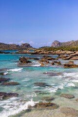 Naklejka na ściany i meble Vertical shot of the rocks in the water in Falasarna Phalasarna beach, Crete island, Greece