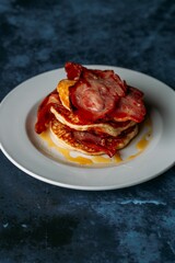 Closeup view of bacon pancake with honey topping on a plate