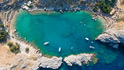 Aerial view of a rocky bay with ships on a sunny day