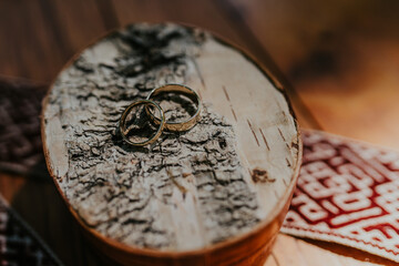 A box made of birch with wedding rings placed inside is photographed in close-up with a soft focus