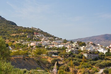 Obraz premium Beautiful shot of a city on mountain with greenery under blue sky