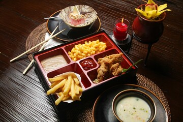 Closeup of delicious fries, chicken strips and mac and cheese on a plate in a restaurant