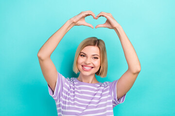 Fototapeta na wymiar Portrait of peasant appreciative woman with stylish hairdo striped t-shirt fingers showing heart symbol isolated on teal color background