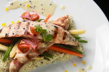 Tasty Asian with fish fillet tomatoes carrot and rice with a delicious sauce