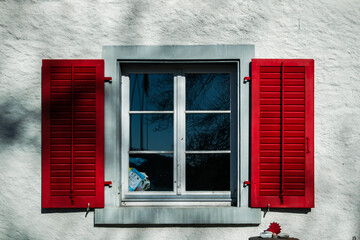 Outdoor window on a building with red wooden shutter