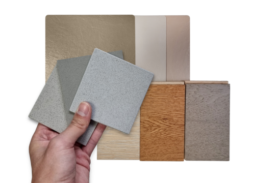 architect's hand holds stone tiles compare color with multi wooden laminated flooring tiles and multi color of leather laminated samples isolated on background with clipping path for selection.