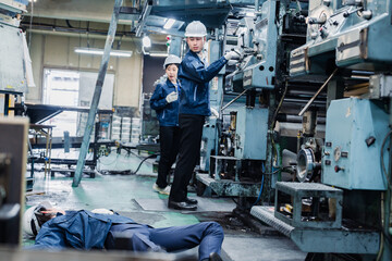 Fototapeta na wymiar 工場で労災が発生し対処をするスタッフ
