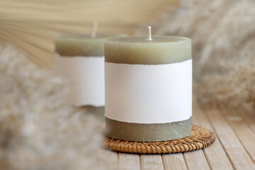 Candles with label on wooden table with dried pampas grass, Close up, copy space. Packaging mock up
