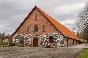 Obraz premium An old ancient building in Scandinavian style from big stones and bricks. Rural area, village, big farm.