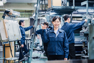 Fototapeta na wymiar おすすめを指差す工場スタッフの女性