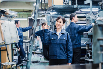 OKサインを示す工場スタッフの女性