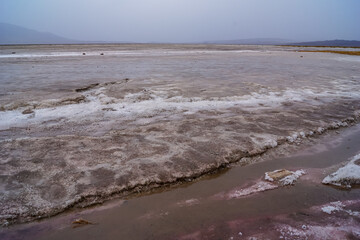 Scenic view of rough surface of rock salt blocks at Devil's Golf Course, Death Valley National Park, California, USA. Remote salt desert extreme terrain landscape on an overcast rainy day in summer