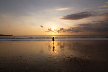 sunset on the beach with a human figure 