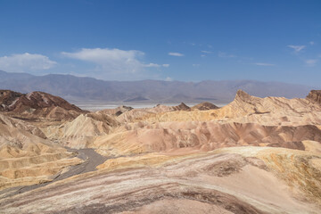Scenic view of Badlands of Zabriskie Point, Furnace creek, Death Valley National Park, California, USA. Erosional landscape of multi hued Amargosa Chaos rock formations, Panamint Range in the back