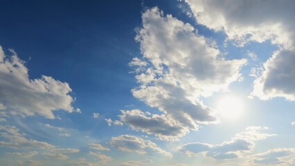 Beautiful white clouds in the blue sky and the rays of the bright sun. The movement of clouds across the sky. Timelapse 4k. - Powered by Adobe