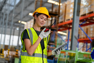 Multiethnic industrial workers checking their logistic lists while working with transportation of goods in warehouse