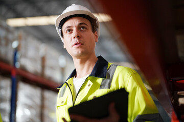 Multiethnic industrial workers checking their logistic lists while working with transportation of goods in warehouse