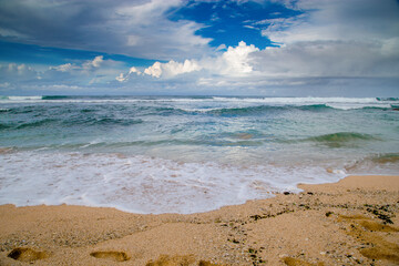 tropical beach under blue sky with white clouds and sea waves
