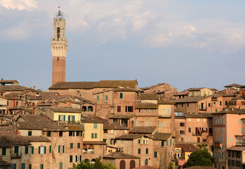 Panorama of Siena with the red houses, the cathedral in Italian Romanesque-Gothic style and the Torre del Mangia overlooking Piazza del Campo.