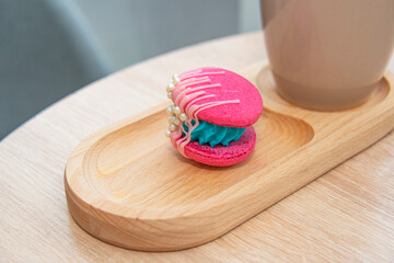 cup of coffee latte and colorful pink macaroons on wooden table