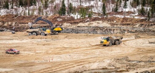 Dumpers and excavator performing excavation work during the construction of a new tailings pond © Larry Dallaire