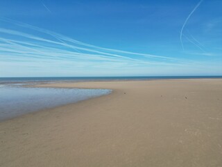 Aerial view of golden sand beach with low tide and blue sky background. Taken in Lytham Lancashire England. 