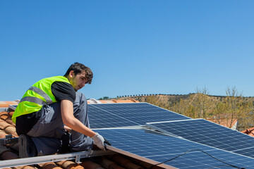 Solar panel technician installing solar panels on the roof. Alternative energy ecological concept.