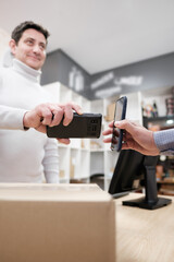 Happy male shopper scanning a parcel code in his smart phone © black dingo