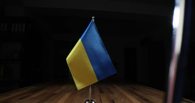 Ukrainian flag standing on negotiating table near European Union and USA 4k movie. International assistance and support to Ukrainian people during war concept