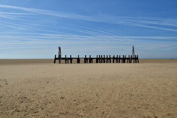 Old wooden pier On St Anne's beach in Lytham Lancashire England. Blue sky background and no people. 