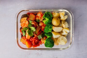 Top view of healthy dinner with vegetables, broccoli and potato in the glass container