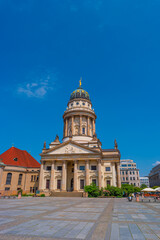Fototapeta premium View over the Gendarmenmarkt in Berlin with French Cathedral in historical and business downtown at summer sunny day and blue sky.