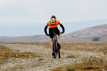 Obraz premium mountainbiker riding sports cycle on mountainous trail in cross-country cycling race