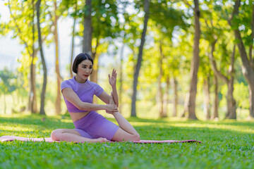 Naklejka na ściany i meble Young Asian woman doing yoga in the garden for exercise and good health. In the park Asian fitness woman doing yoga and relaxing with sportswear in green park in summer