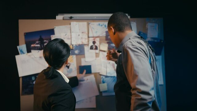 Middle-aged female detective and her male colleague working on a case together
